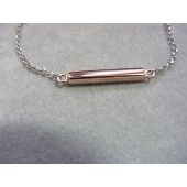 Zilveren armband met rose kleurig balkje ertussen.