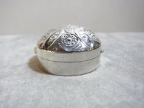 Zilveren pillendoosje met bewerkte bolle deksel.